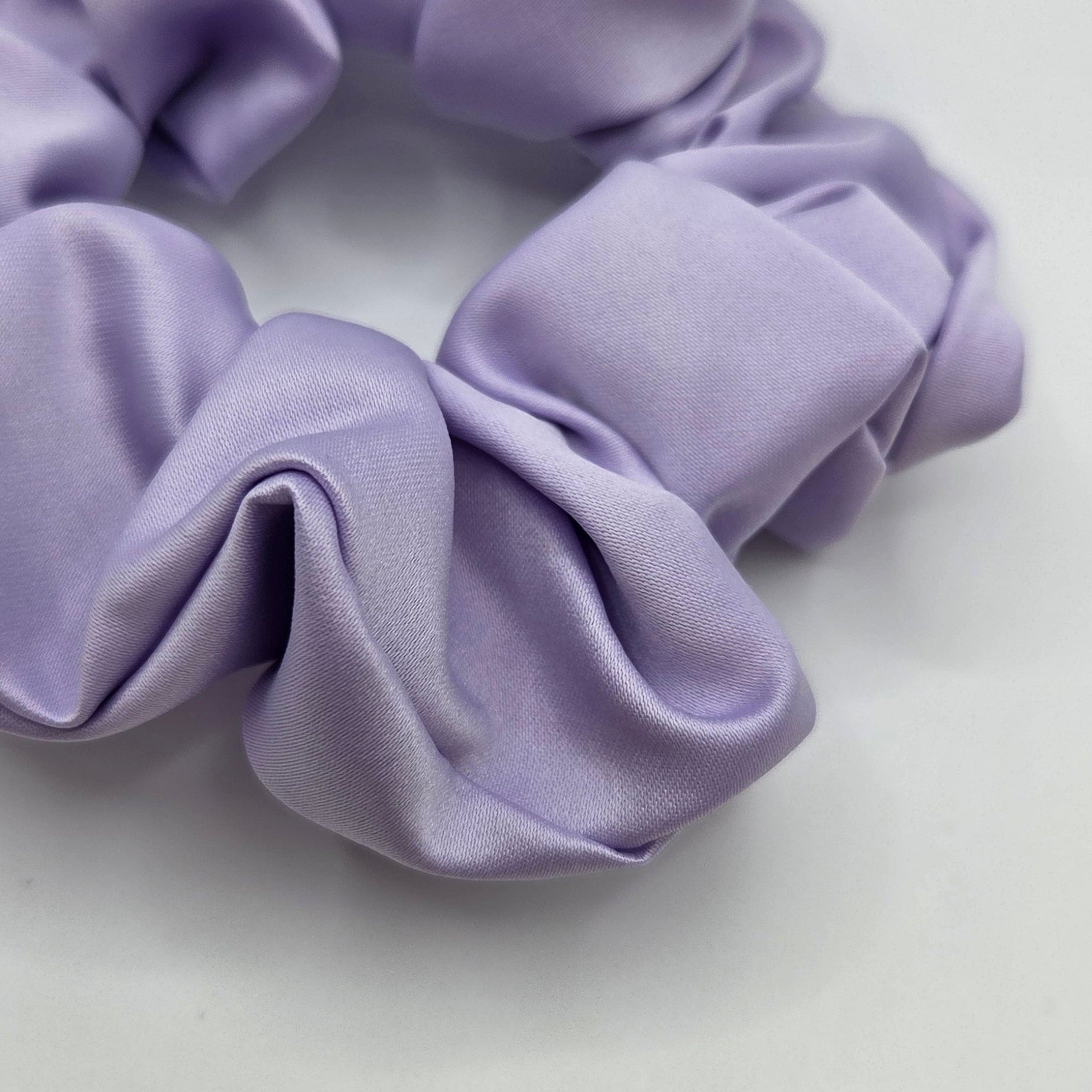 A lavender purple fabric scrunchie shown on a plain white background.